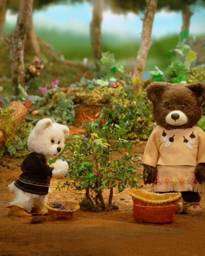 Still from Spirit Bear movie showing Spirit Bear and Mary the Bear harvesting berries